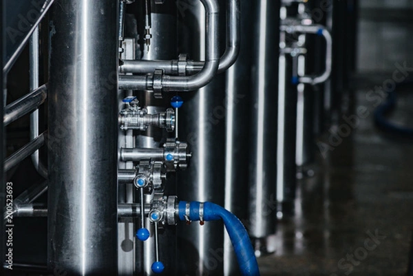 Fototapeta Pipes for giving of malt and water, valves in stainless steel pipes. Clean high quality pipeline in industrial interior