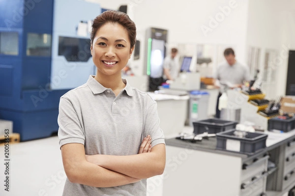 Fototapeta Portrait Of Female Engineer On Factory Floor Of Busy Workshop