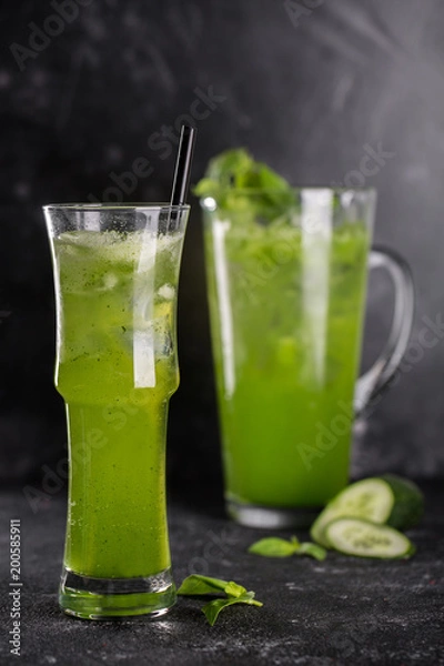 Fototapeta Homemade flavored lemonade with a glass on a dark background
