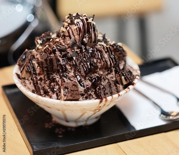 Obraz Chocolate ice snowflakes with chocolate ice cream and brownies topping. This is famous dessert in hot summer. 
