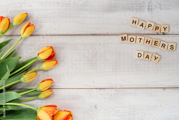 Fototapeta Yellow and red tulips on whitewashed wood with Mother's Day message