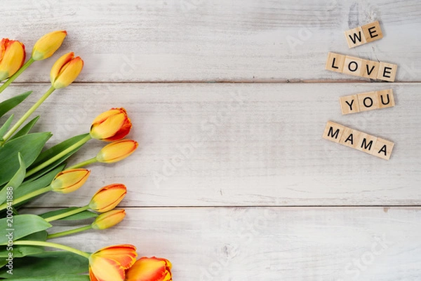 Fototapeta Yellow and red tulips on whitewashed wood with Mother's Day message