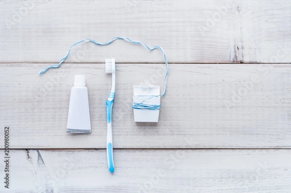 Fototapeta Toothbrush, toothpaste and dental floss on a weathered wood background
