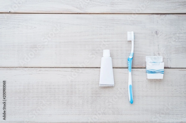 Fototapeta Toothbrush, toothpaste and dental floss on a weathered wood background
