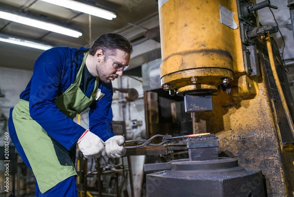 Obraz A brutal man works in a workshop