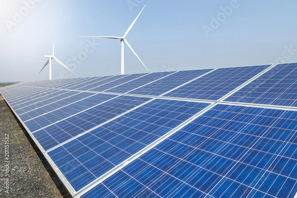 Fototapeta      Rows array of  polycrystalline silicon solar panels and wind turbines generating electricity in hybrid power plant systems station 