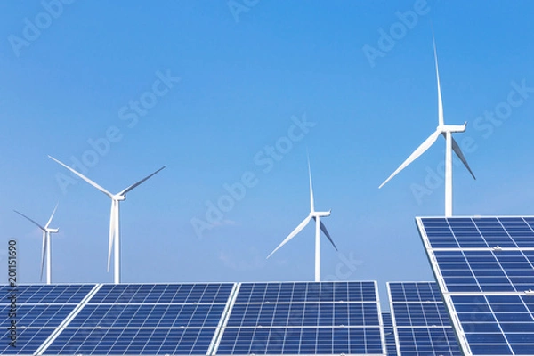 Fototapeta Rows array of  polycrystalline silicon solar panels and wind turbines generating electricity in hybrid power plant systems station with blue sky 