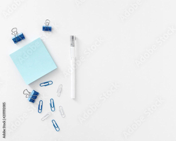Fototapeta Office table with pen, note papers and paper clips top view
