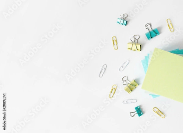 Fototapeta Office table with note papers and paper clips top view