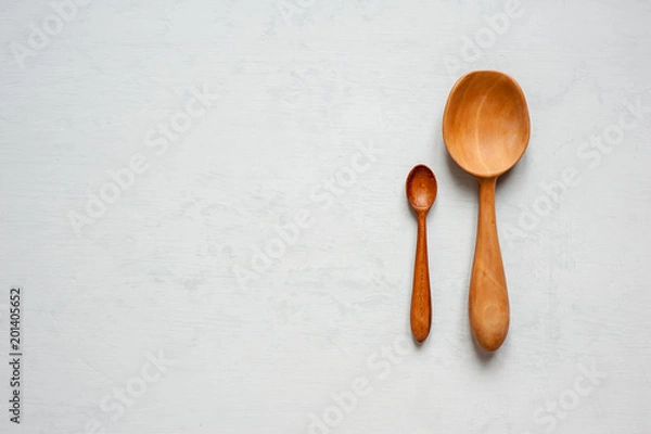 Fototapeta Wooden hand-made spoons lay on a gray background.