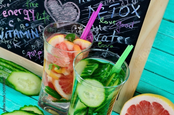Obraz glass water with cucumber and grapefruit on table