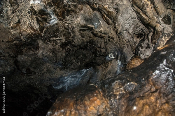 Fototapeta View inside a deep cave. The dark abyss.