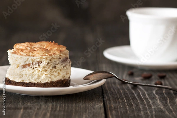 Fototapeta Tiramisu cake on a white saucer and a cup of black coffee