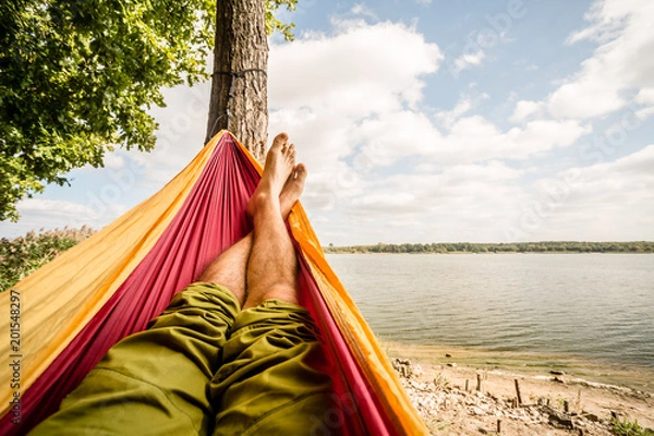 Obraz Relaxing in the hammock at the beach under trees, summer day