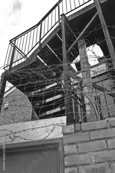 Obraz Industrial staircase surrounded by barbed wire.