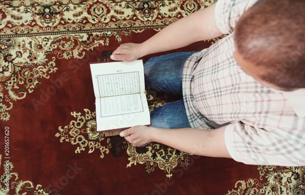 Obraz Muslim man reading Islamic holy book quran