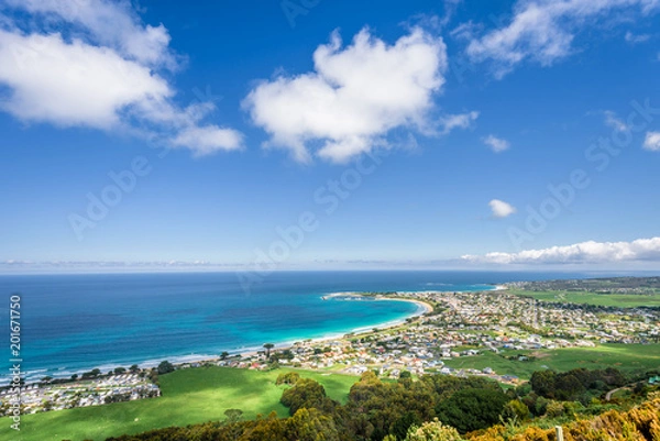 Fototapeta Relaxing at the blue Bass Strait sea and enjoying a warm sunny beach view over blue sky water of Great Ocean Road with a few clouds horizon over small town Apollo Bay, Melbourne, Victoria, Australia