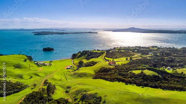Fototapeta Aerial view on a shore on sunny harbor with small houses. Waiheke Island, Auckland, New Zealand.