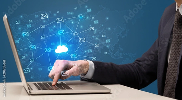 Fototapeta Businessman hand sending a bunch of messages on laptop with cloud computing concept
