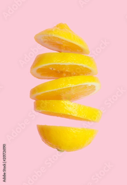 Fototapeta Flying lemon. Sliced lemon isolated on gradient pink background. Levity fruit