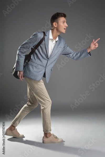 Fototapeta Punctuality concept. Side view profile of pleased good looking man running with backpack