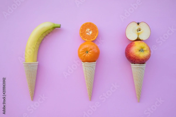 Fototapeta Fresh fruit orange, tangerine, apple in ice cream on pink background