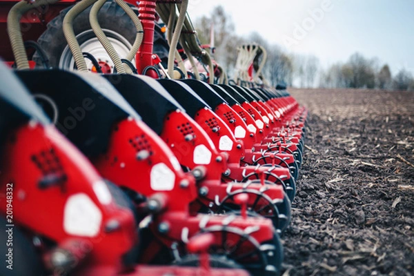Obraz sewing machine with discs stands on the ground in the field in the spring