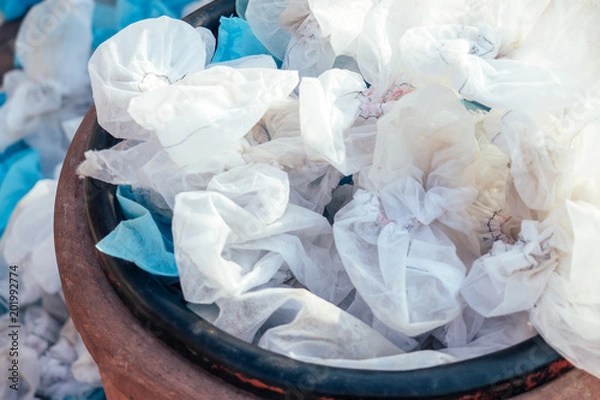 Obraz white used medical shoe covers in trash. the concept of hygiene and protection. environmental pollution