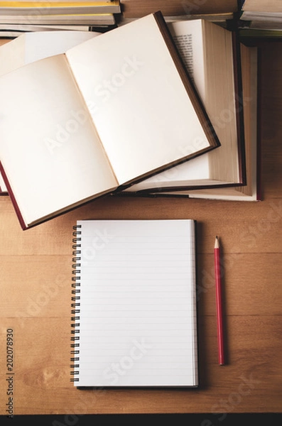 Fototapeta Opened Educational Books Stacked on Desk from Above