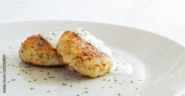 Fototapeta fish cutlets with sour cream mayo sauce sprinkled with dill