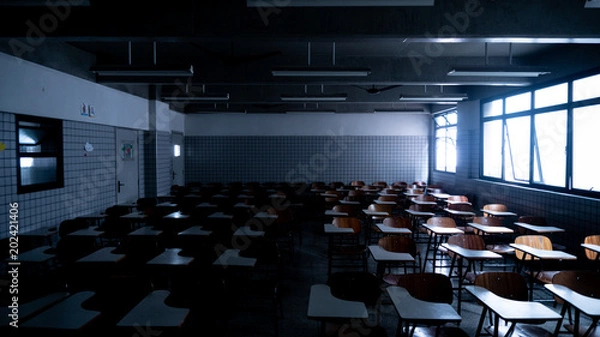 Fototapeta Empty classroom illuminated by some shiny windows