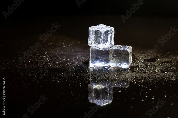Fototapeta ice cubes reflection on black table background.