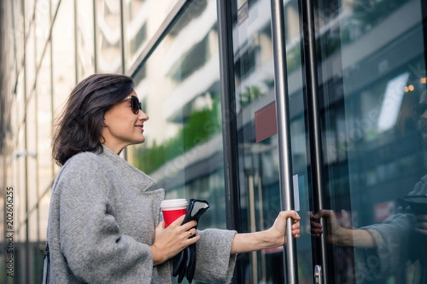 Obraz Smiling businesswoman entering in office building.