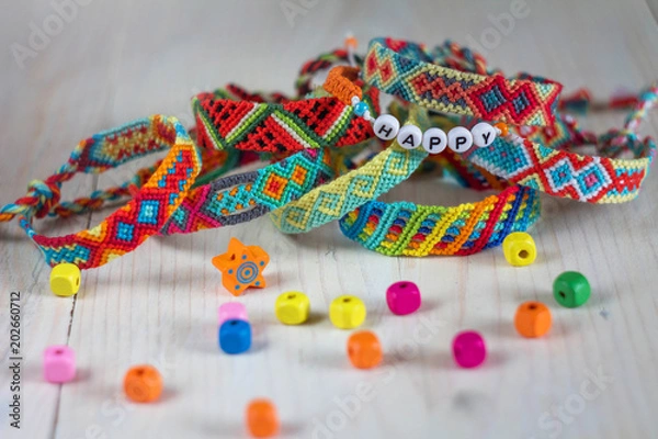 Fototapeta handmade friendship bracelets with colorful threads on light background