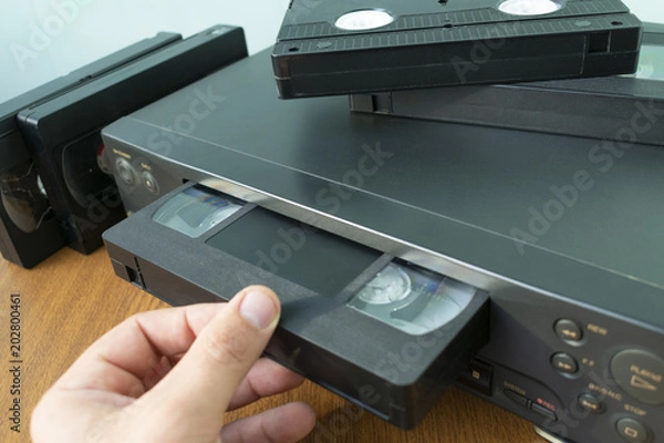 Obraz insert a videotape into a tape recorder