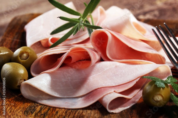 Fototapeta Sliced ham on wooden background. Fresh prosciutto. Pork ham sliced