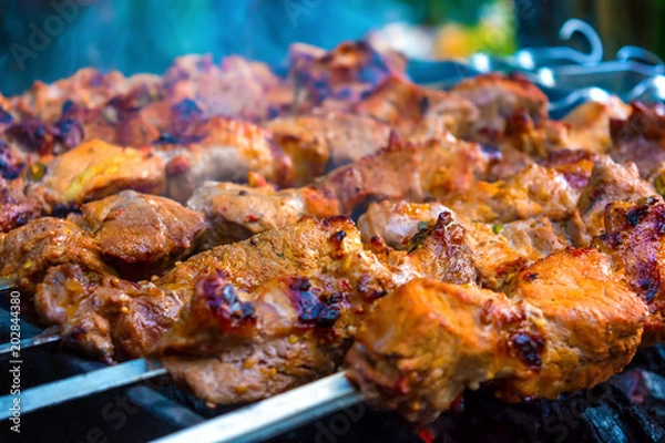 Obraz Photo of delicious pork barbecue fried on charcoal in the park