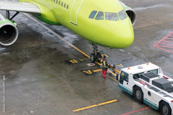 Obraz Towing the aircraft from the runway to the Parking lot with the help of special equipment.