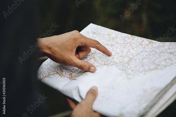 Fototapeta Caucasian man looking at a map travel and explore concept