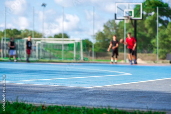 Obraz Abstract, blurry background of boys playing basketball in outdoor basketball court in park