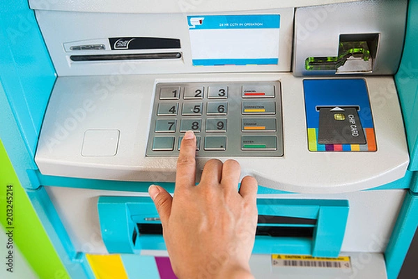 Fototapeta Enter ATM code,Withdrawing money from an ATM,Enter the code on the ATM keyboard on top view
