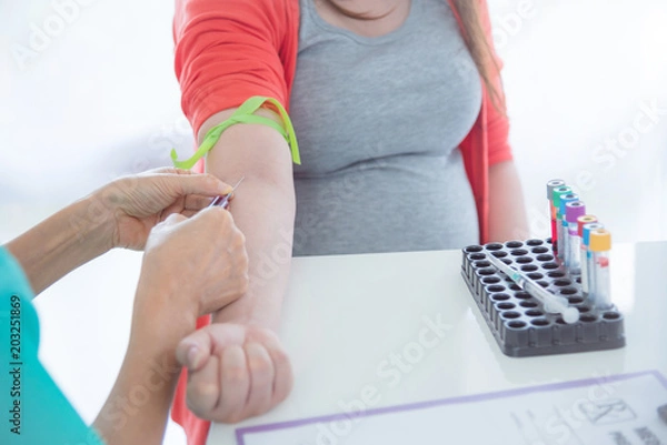 Obraz Doctor using syringe taking blood from pregnant woman