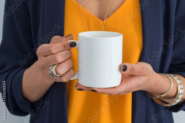 Fototapeta womans hands holding a white mug, perfect for displaying your quote, design on mugs you sell.