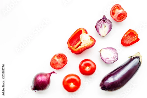 Fototapeta Layout of contrast, colored vegetables. Eggplant, red onion, red pepper, tomato on white background top view copy space pattern