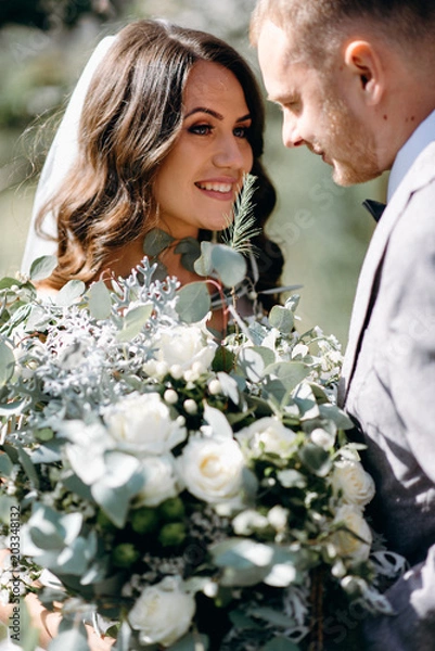 Obraz The first meeting of the bride and groom on their wedding day in the garden. Waiting and emotions of the newlyweds. The first kiss of the bride and groom