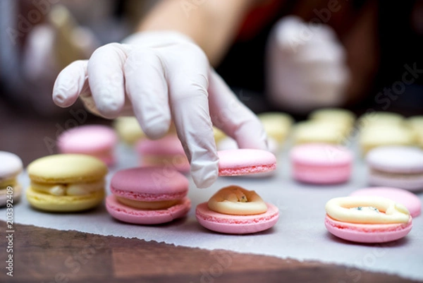 Fototapeta cooking, confectionery and baking concept - macarons on table