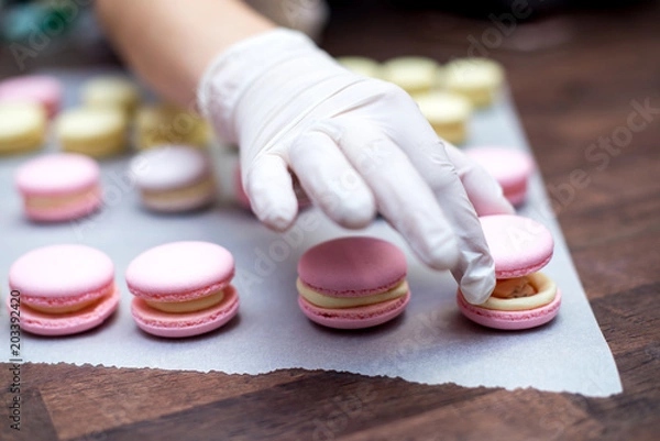 Fototapeta cooking, confectionery and baking concept - macarons on table