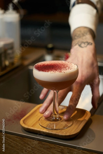 Fototapeta Professional bartender making a cocktail at the bar counter, close-up