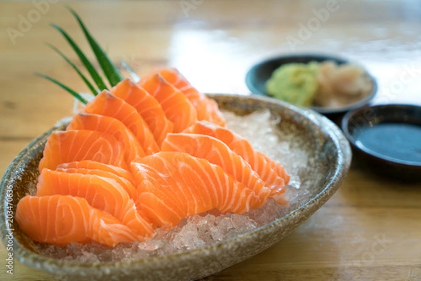 Fototapeta Raw salmon slice or salmon sashimi in Japanese style fresh serve on ice in bowl.