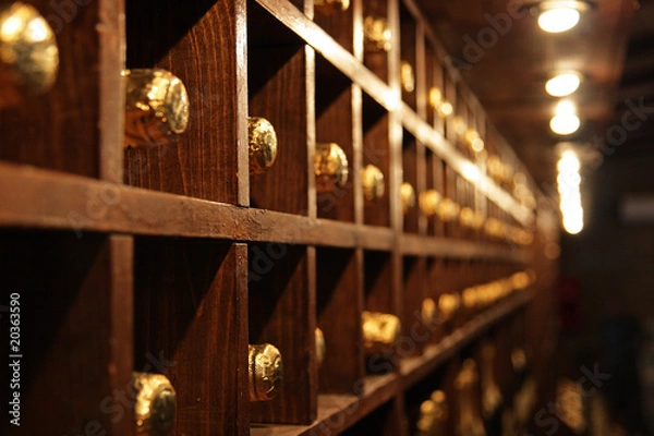 Obraz Racks with bottles in a dark wine cellar